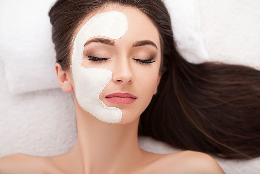 rosto de mulher com máscara de peeling no lado esquerdo